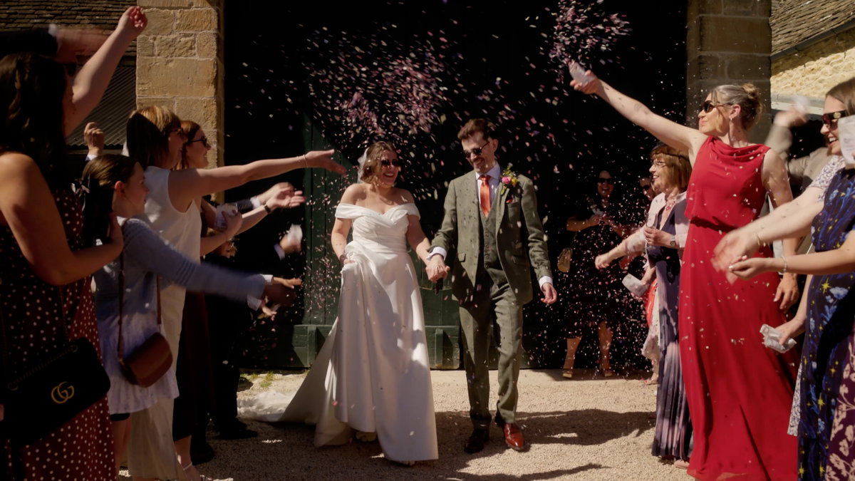 Phil and Maddy celebrating their wedding at Cogges Manor Farm in Witney