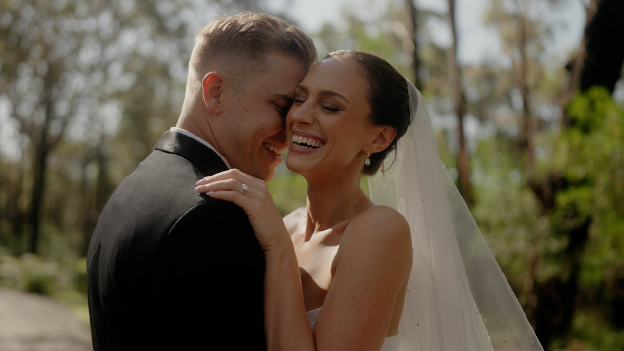 Nat and Ed laughing cheek to cheek among the gum trees